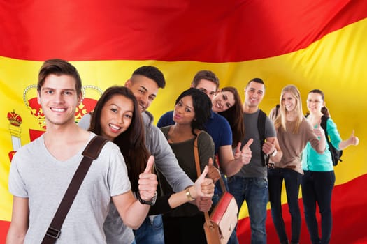 Portrait of college students gesturing thumbs up while standing in a line over white background