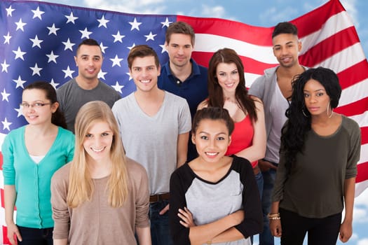 Group portrait of smiling multiethnic college students standing together in classroom