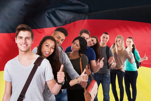 Portrait of college students gesturing thumbs up while standing in a line over white background