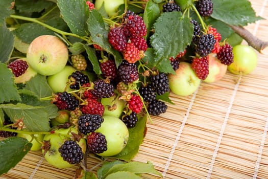apples and raspberries on a wooden table