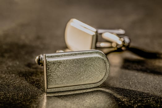 A set of cufflinks lie on a table.