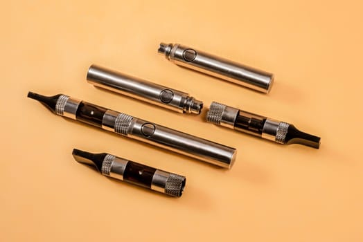The different parts of an electronic cigarette displayed with three such cigarettes.