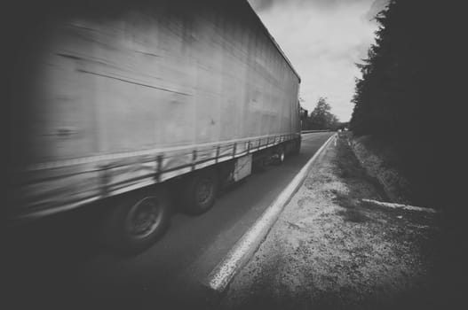 black and white truck speeding on country highway,motion blur