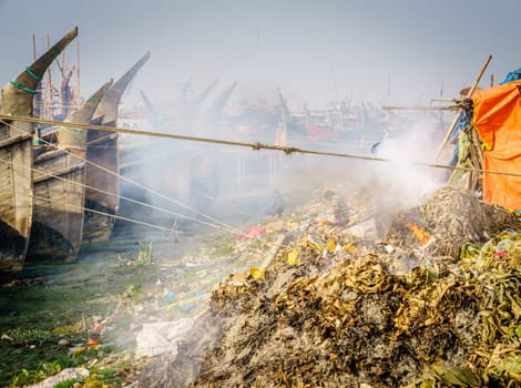 Seaweed smoldering on the bank of the Karnaphuli River in Chittagong, Bangladesh