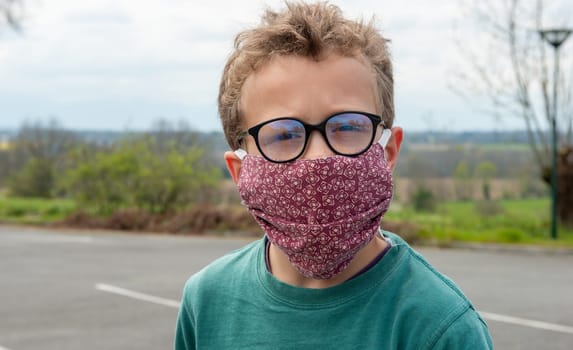 a child wearing anti virus mask, outdoors