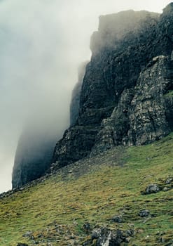 Mountains in Scotland with fog and grass in a cloudy day
