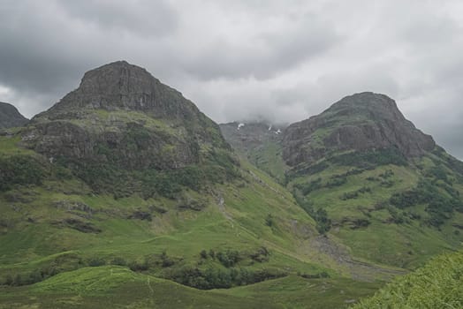 Landscape of nature in Scotland, three mountains with fog at top and no people