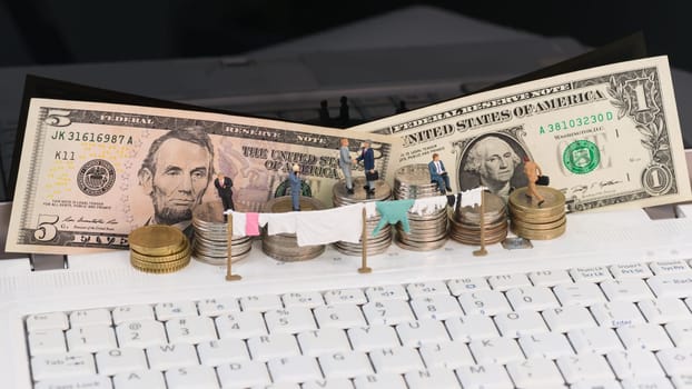 Money laundering concept with miniature people, clothesline and coins