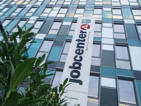 Berlin, Germany - January 27, 2020: Low angle view of the window front with large vertically mounted inscription of the job center in Berlin-Lichtenberg.
