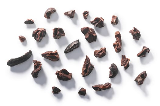 Cacao nibs, a pieces of broken cocoa beans isolated, top view