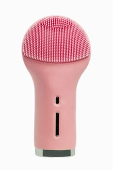 Beauty and skin care concept. Close-up of a modern pink, electrically rechargeable silicone brush for facial cleansing with massage vibration isolated on a white background. Macro photography.