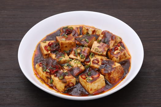 Chinese cuisine mabo tofu in a dish on wooden table