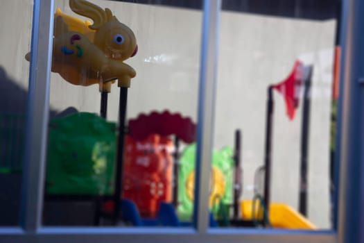 Children playground reflection on window glass, stock photo