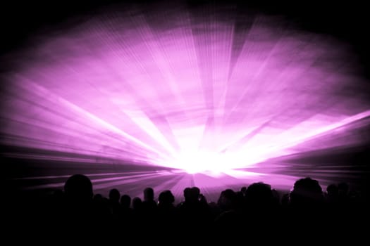Luxury entertainment with audience silhouettes in nightclub event, festival or New Years Eve. Beams and rays shining colorful lights.