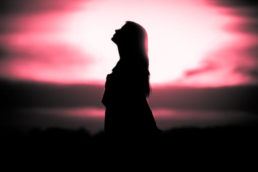 Silhouette in front of sunset or sunrise in summer nature. Symbol for healing burnout therapy, wellness relaxation or resurrection.