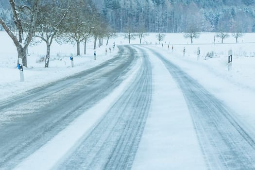 The street track is slick frozen. High dangerous risk of accident through blizzard snowstorm and severe christmas time season weather.