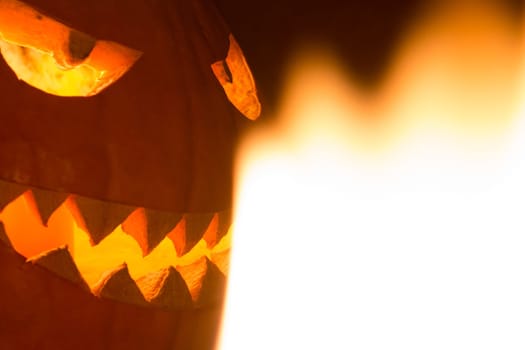 Big helloween autumn symbol with mad face, glowing eyes, mouth and teeth. Scary hot nightmare horror with evil smile at october 31st.