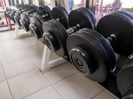 dumbbell set. Close up many metal dumbbells on rack in sport fitness center