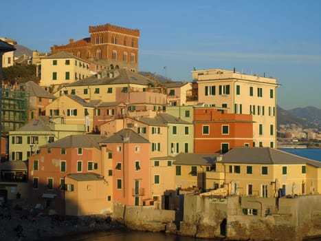 Genova, Italy - 11/25/2019: An amazing caption of the sunset in winter days over the sea of Genova with beautiful red and blue sky, some amazing clouds in the background and old rocks over the sea.