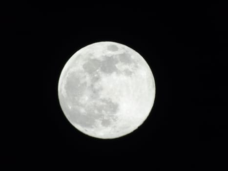 An amazing photography of the full moon over the city of Genova by night with a great clear sky in background and some stars