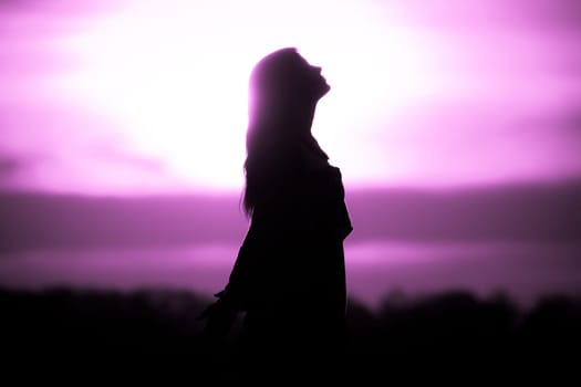Silhouette in front of sunset or sunrise in summer nature. Symbol for healing burnout therapy, wellness relaxation or resurrection.