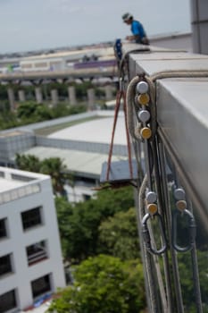 workers cleaning windows service on high rise building