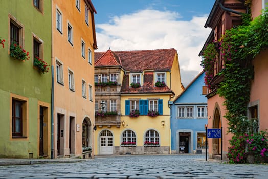 Empty old street in Rothenburg Ob Der Tauber, Bavaria, Germany, Europe. Old german architecture. Blue cloudy sky in background