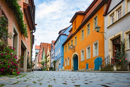 Empty old street in Rothenburg Ob Der Tauber, Bavaria, Germany, Europe. Old german architecture. Blue cloudy sky in background
