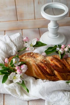 Tasty braided buns on lacy napkin and shabby table