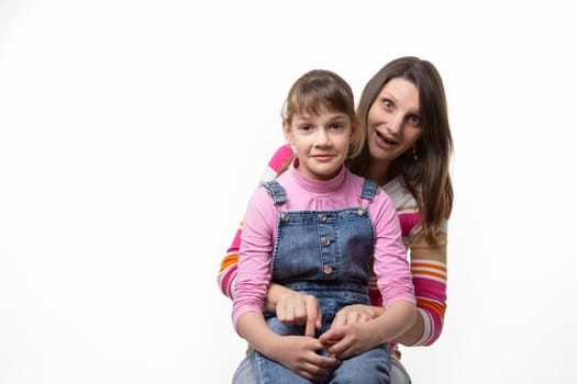 A girl sits on her mothers lap and stares in surprise at the frame