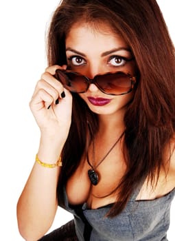 A beautiful young woman with brunette hair looking over her sunglasses.with a nice décolleté, looking serious, isolated for white background.