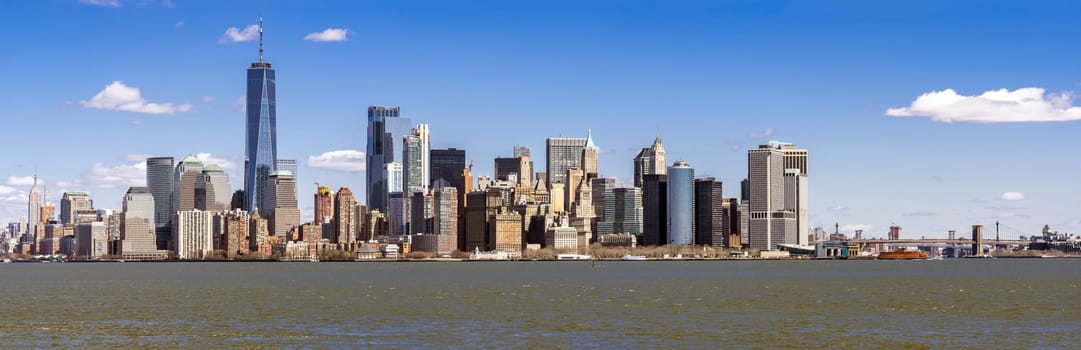 Panorama of Lower Manhattan of New York City with USA Flag from liberty island. This also known as Downtown Manhattan or Downtown New York the largest business district in state of New York and USA.