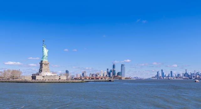 Panoramic landscape of Statue of Liberty with Manhattan downtown Skylines skyscraper building in background, NYC, New York State USA. New York Landmark Travel Destination and cityscape concept.