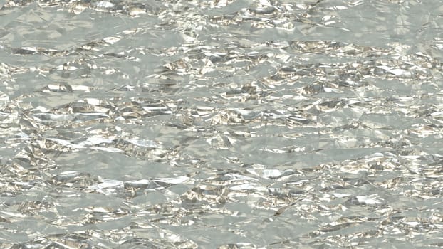 White shiny crumpled metallic foil seamless background texture surface.