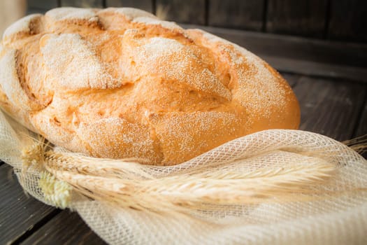 traditional bread with ears on dark rustic wooden table