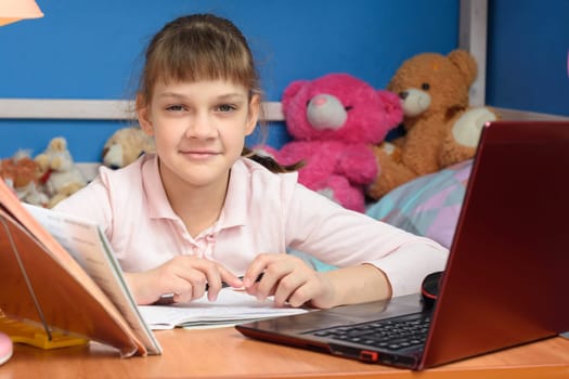remote learning at home with a laptop and a textbook