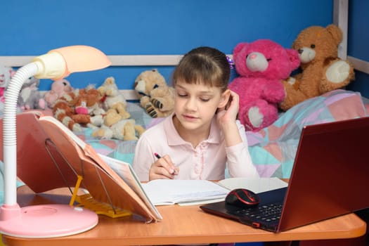 Girl studies at home in front of laptop