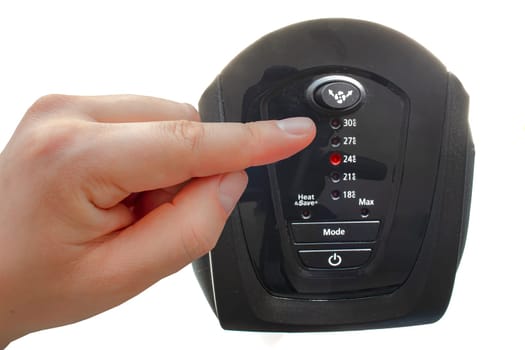 A person turning on a ceramic mini tower heater on a white background