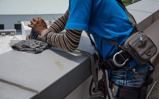 workers cleaning windows service on high rise building