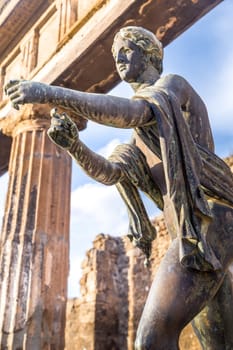 Pompeii in Italy, ruins of the antique Temple of Apollo with bronze Apollo statue, Naples.