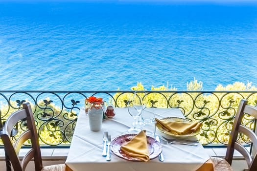 Restaurant table overlooking the sea on the Amalfi coast in Italy.