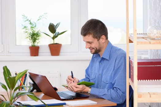 Office employee takes notes in a diary