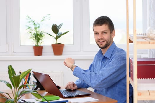 A business man checks the time with a wrist watch and looked into the frame