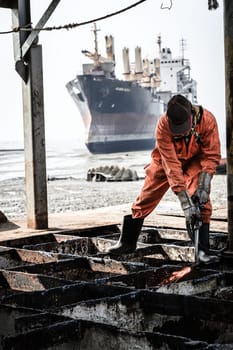Chittagong, Bangladesh, December 23, 2017: A worker is cutting through metal deck structure of a ship at a ship-breaking yard in Chittagong, Bangladesh