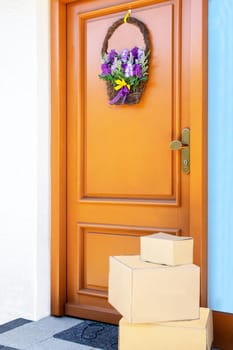 Coronavirus quarantine concept. Contactless delivery service of three packages placed at the door of house during pandemic. Stay at home and avoiding social contact and distance.