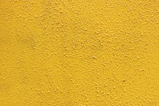 Yellow rough paint concrete wall surface. Painted cement structure.