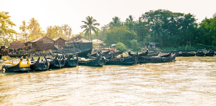 Row boats by a village on the shore of Karnaphuli River near Chittagong, Bangladesh