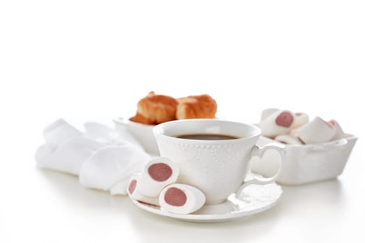 Sweet meal. Dessert. Still life with cup of coffee and bowls with marshmallows and croissants on white background.
