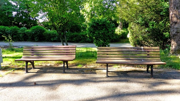 empty park benches with sun and shadow