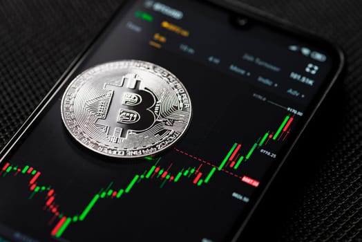 Bitcoin silver coin cryptocurrency trading on smartphone close up